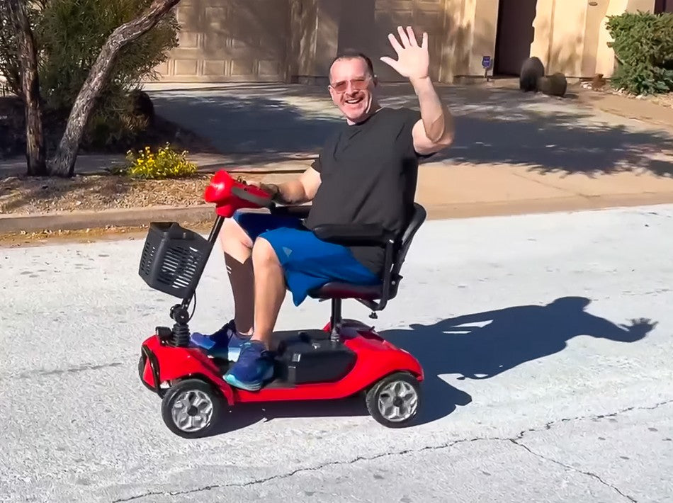 a man is waving hand on a Hoverfly T4 mobility scooter