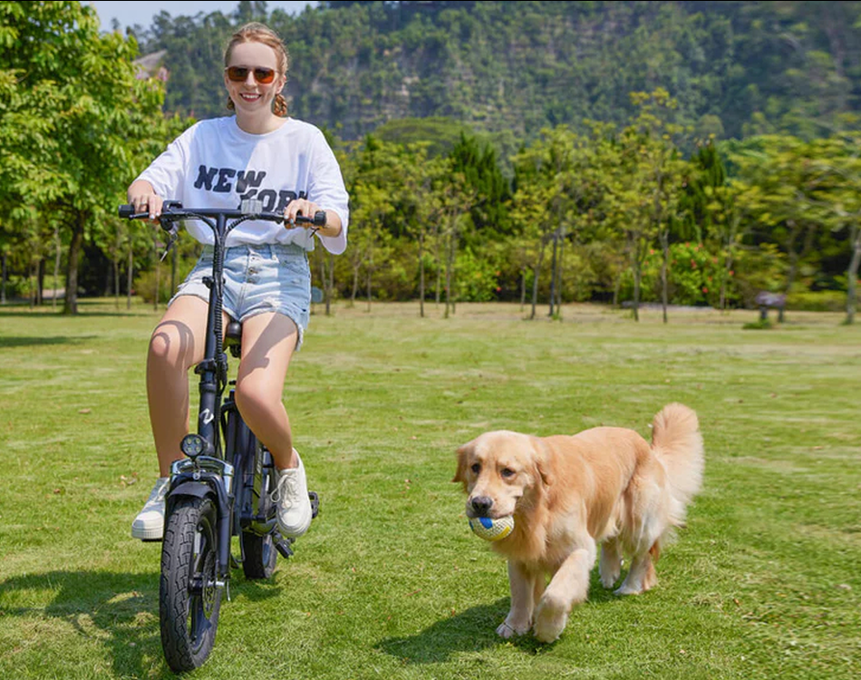 A girl riding an electric scooter with a puppy on the grass
